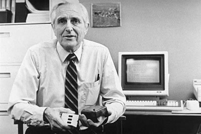 Doug Engelbart holding an early computer mouse